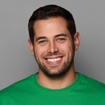 A headshot of Chris Gannon wearing a green shirt in front of a gray background.